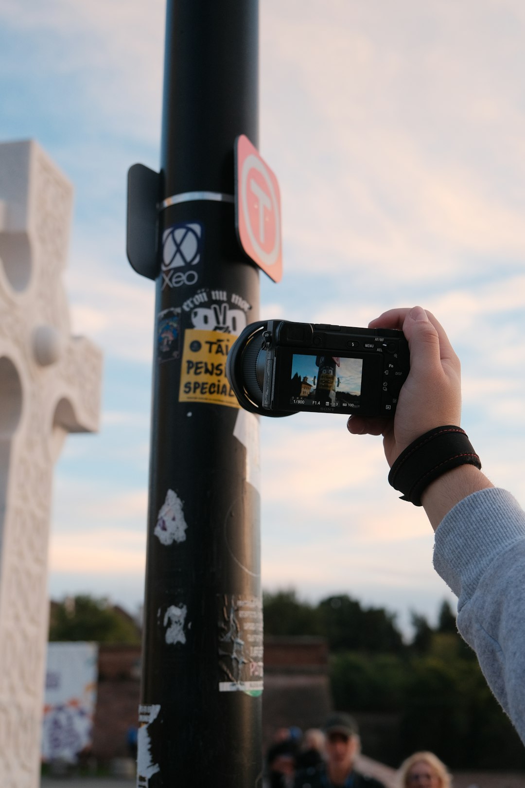A content creator filming a street scene with a compact camera