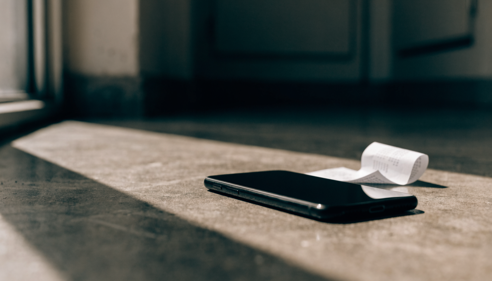 A phone and a receipt on a table A phone and a receipt on a table