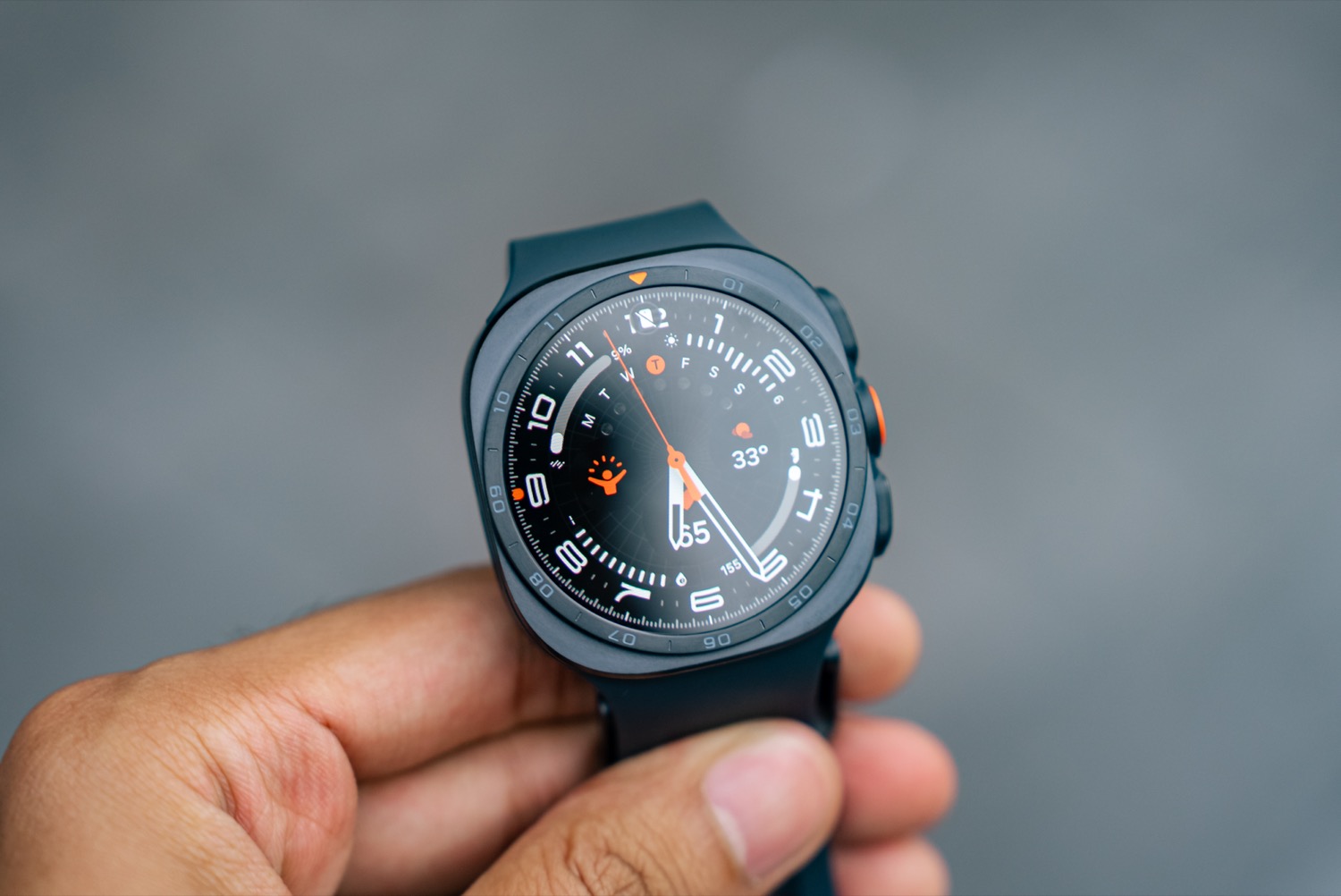 The Samsung Galaxy Watch Ultra 2 held in one hand showing its titanium case and orange accents The Samsung Galaxy Watch Ultra 2 held in one hand showing its titanium case and orange accents