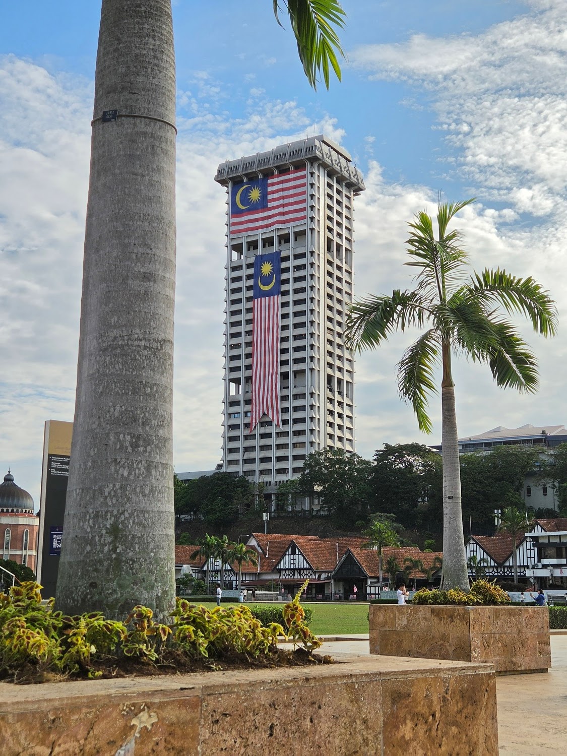 Two flags down a tower above the mock-Tudor roofline of the Royal Selangor Club, shot on the Galaxy Z Fold8 Two flags down a tower above the mock-Tudor roofline of the Royal Selangor Club, shot on the Galaxy Z Fold8