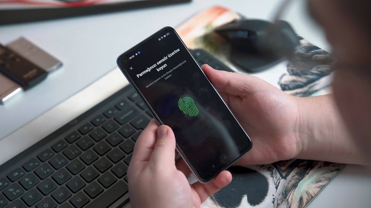 A person approving an action with a fingerprint sensor on a smartphone
