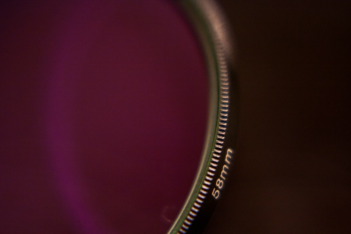 Close-up of a 58mm camera lens element and filter ring