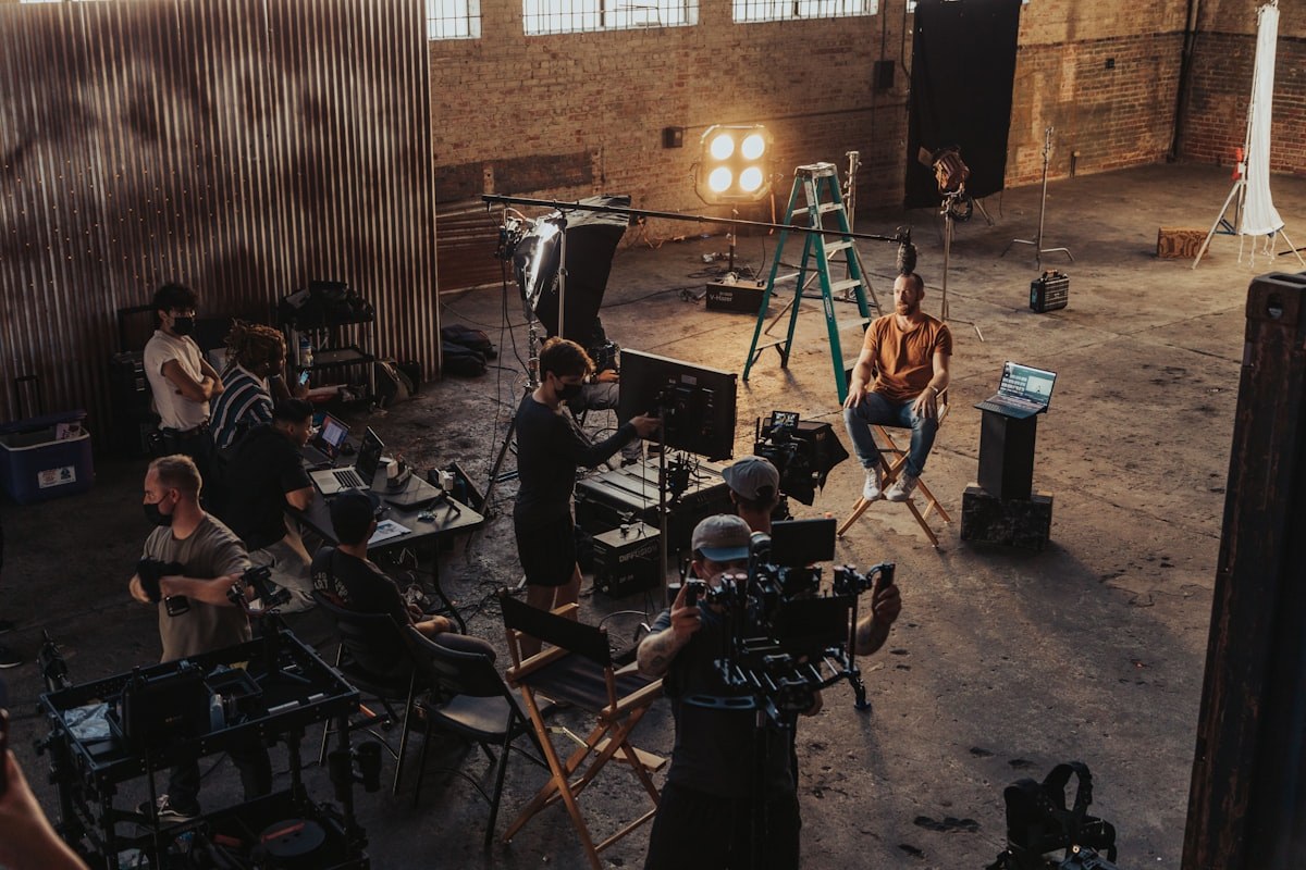 A film crew at work on a production set with lighting and camera gear