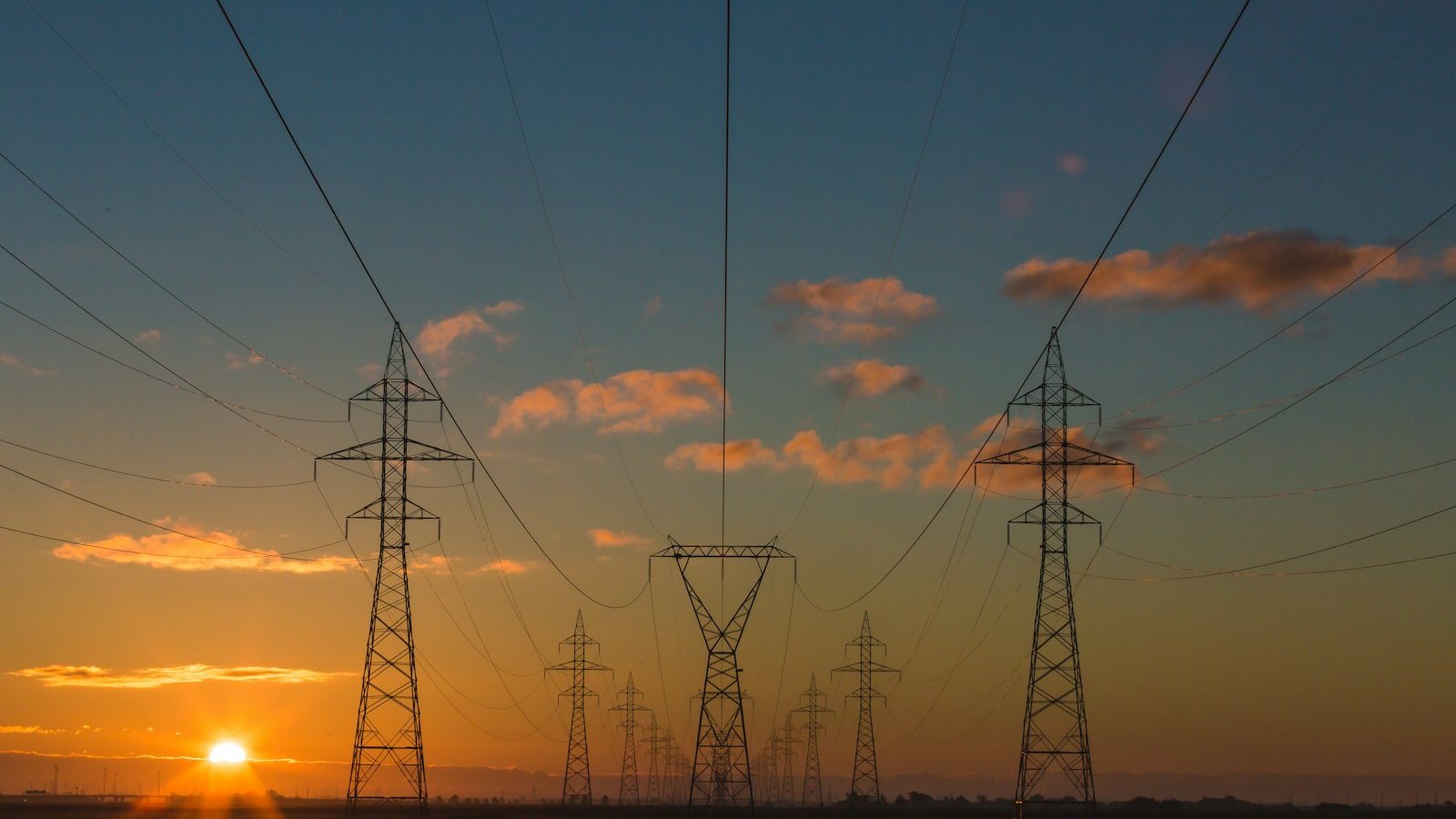 Menara penghantaran elektrik voltan tinggi ketika matahari terbenam