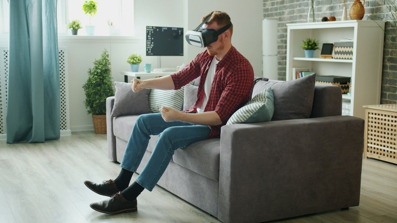 A man on a sofa at home using a virtual reality headset