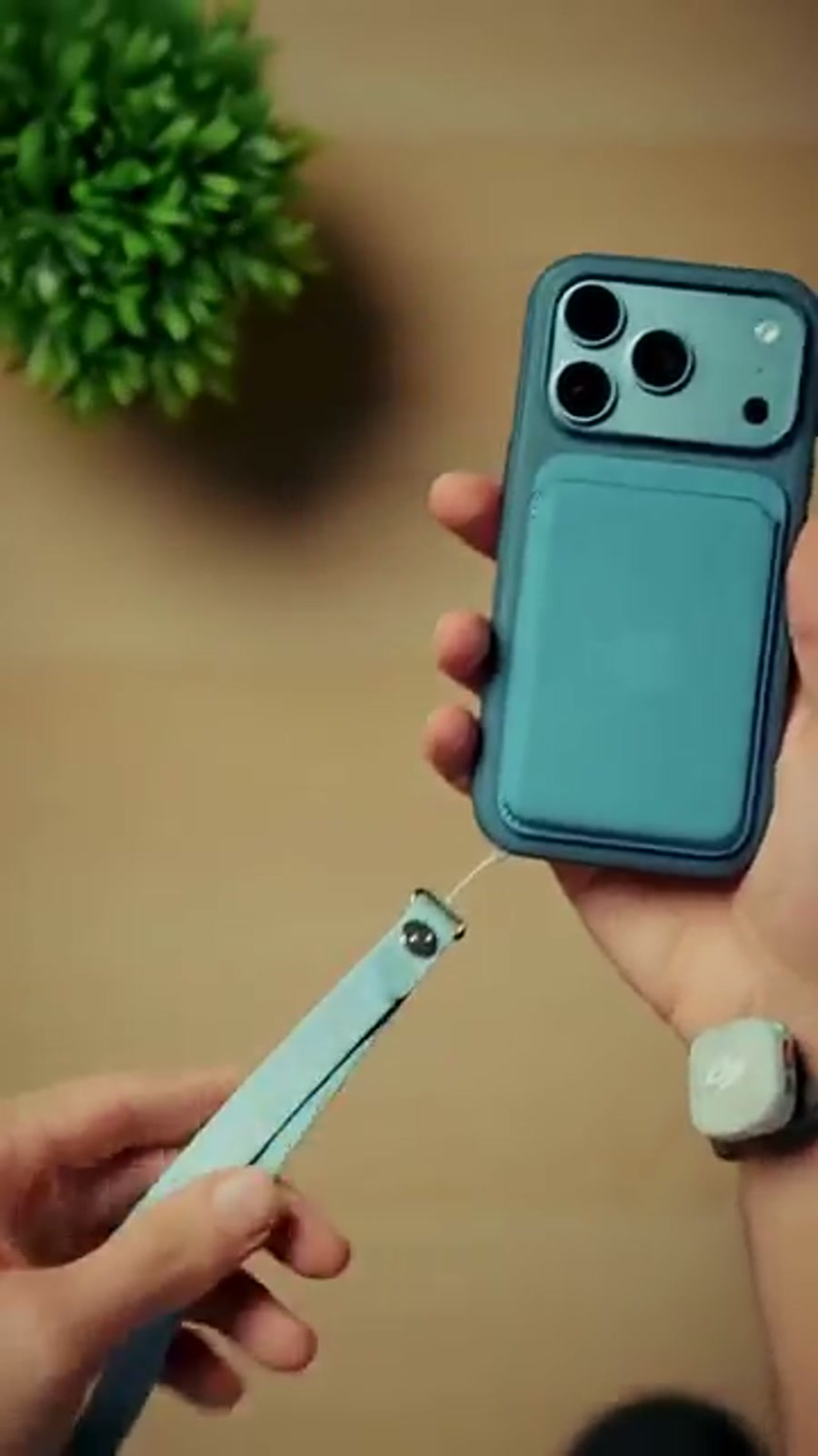 iPhone 18 Pro Max in a case with a card pocket, held up by its own wrist strap iPhone 18 Pro Max in a case with a card pocket, held up by its own wrist strap