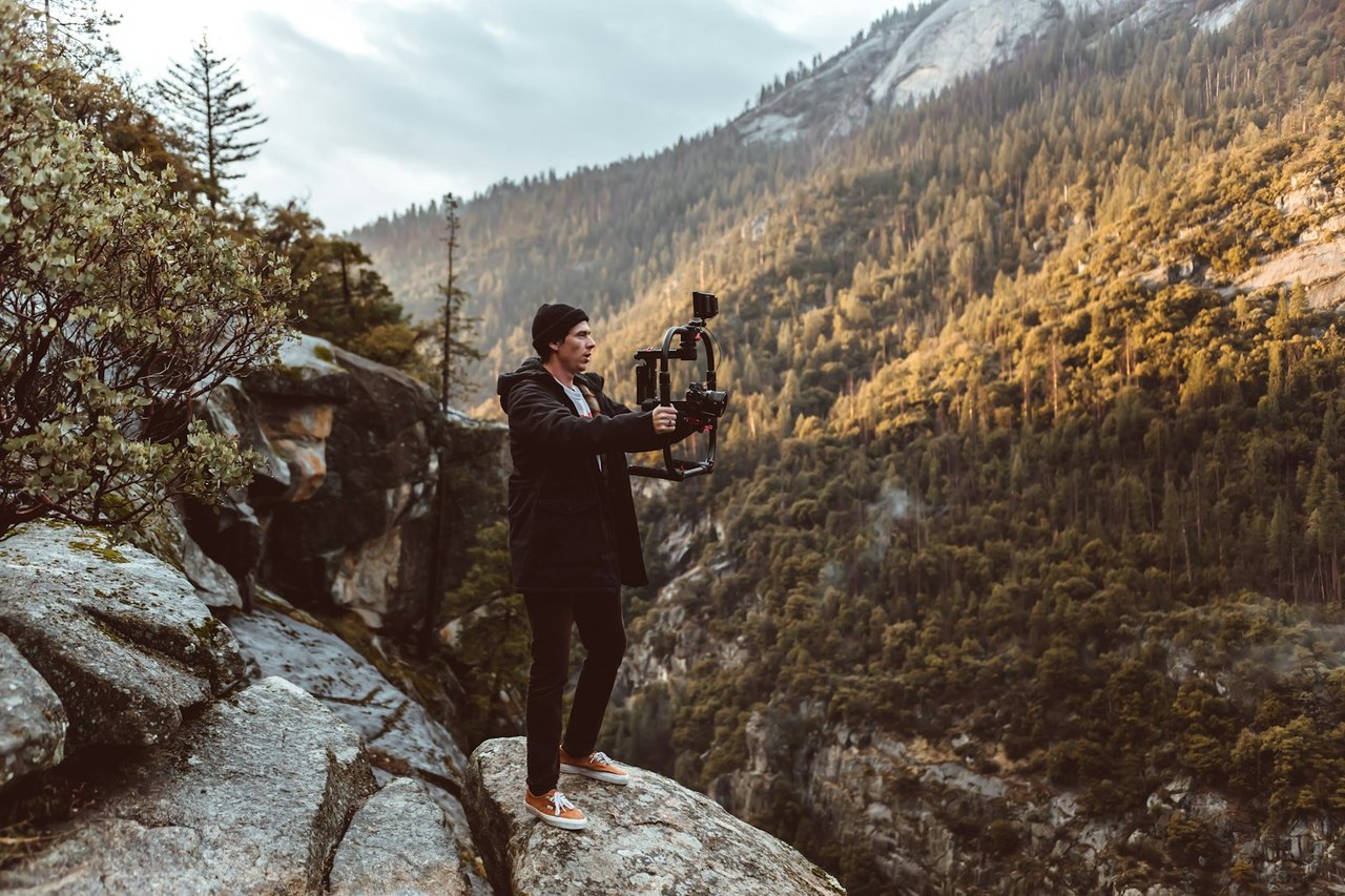 A creator filming outdoors in a valley