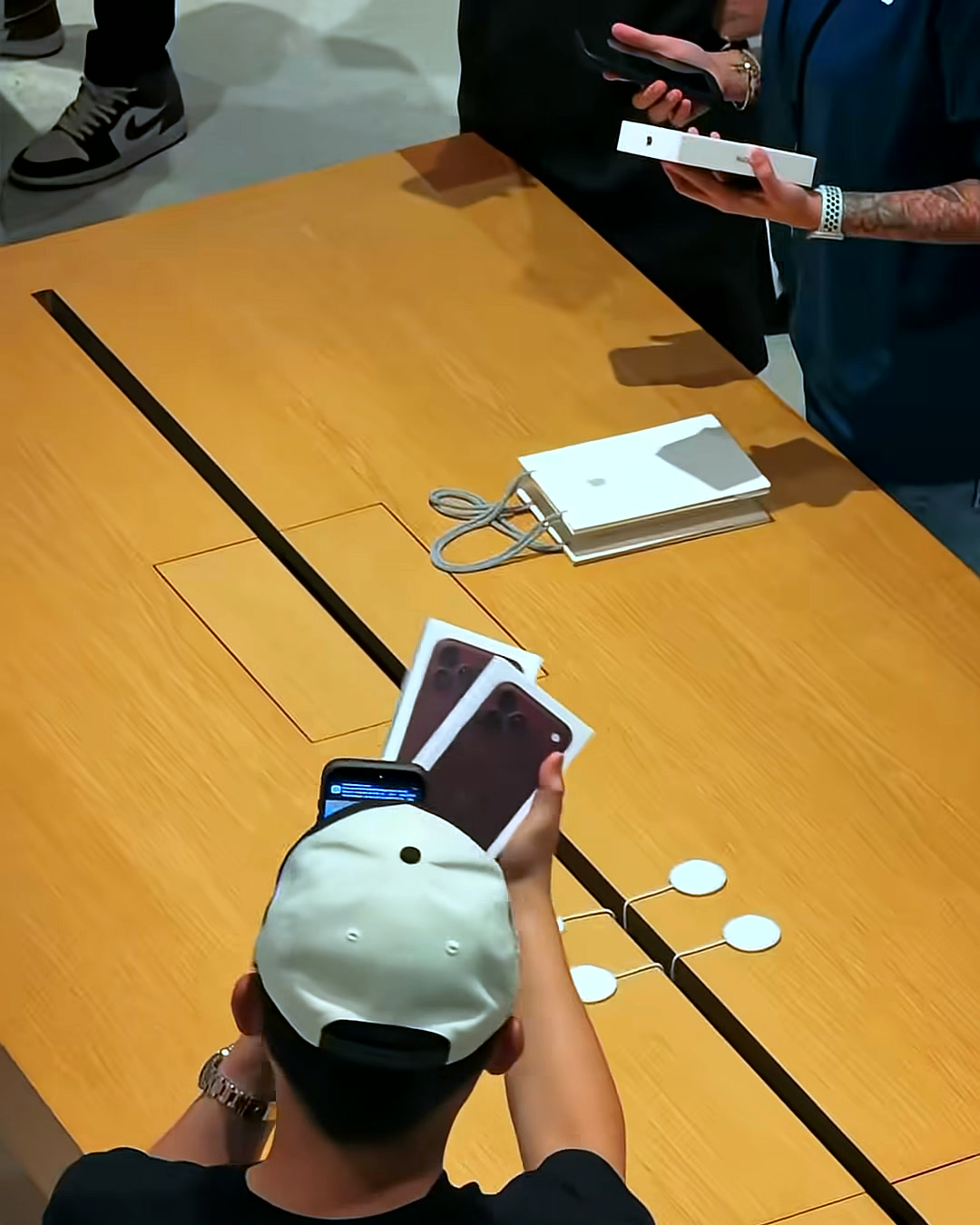 A buyer unboxes his Burgundy iPhone 18 Pro at the Apple TRX counter A buyer unboxes his Burgundy iPhone 18 Pro at the Apple TRX counter