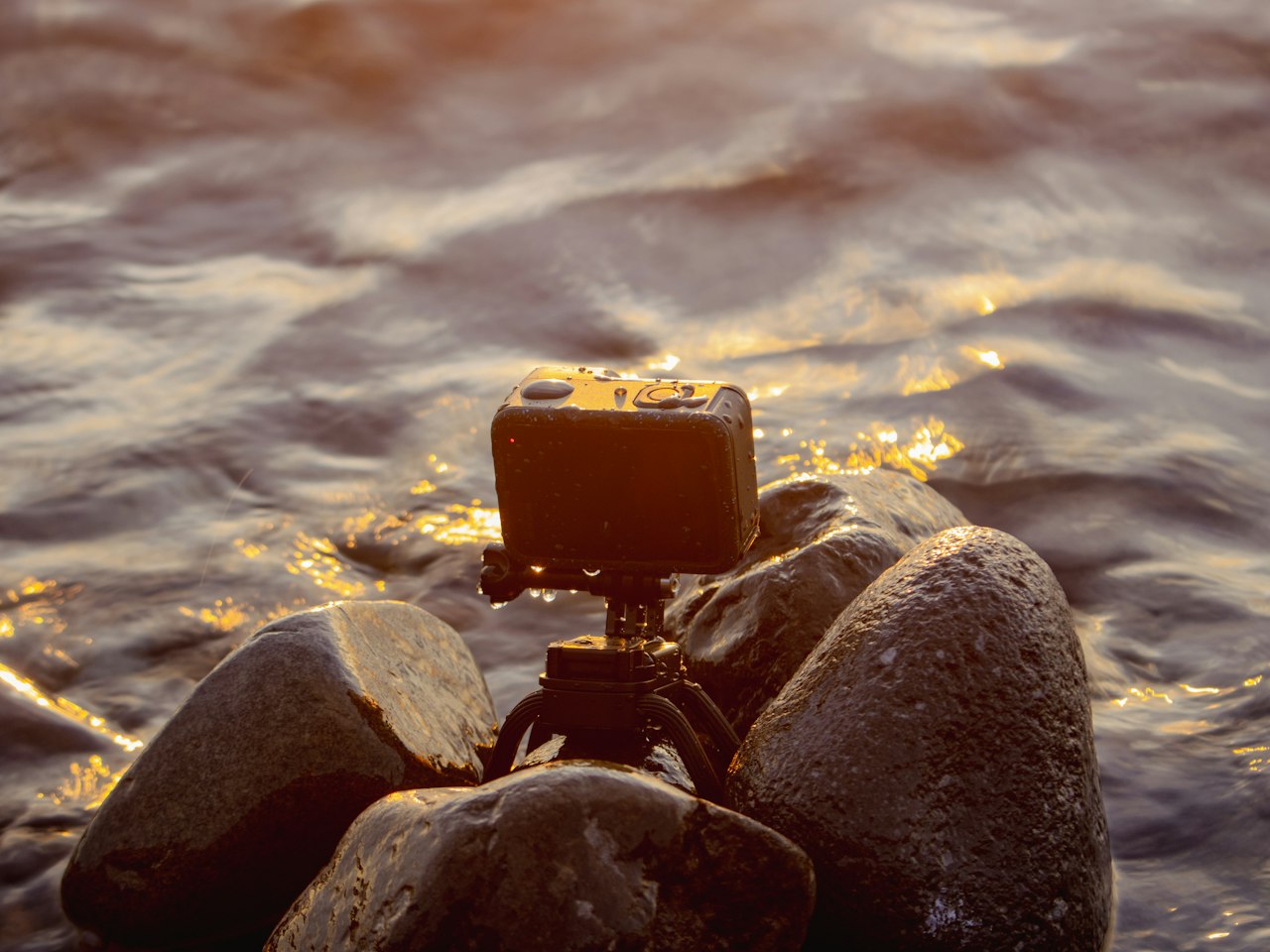 Sebuah kamera aksi di atas tripod kecil dalam air yang mengalir