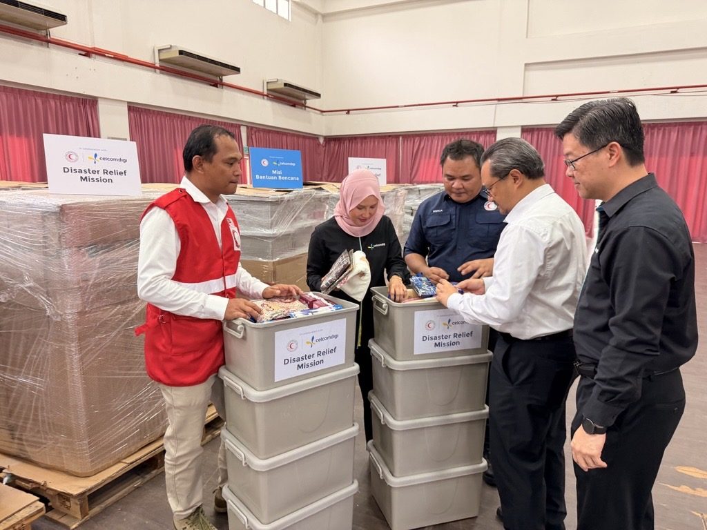 Pasukan CelcomDigi memeriksa barangan bantuan banjir bersama Bulan Sabit Merah Malaysia sebelum diedarkan