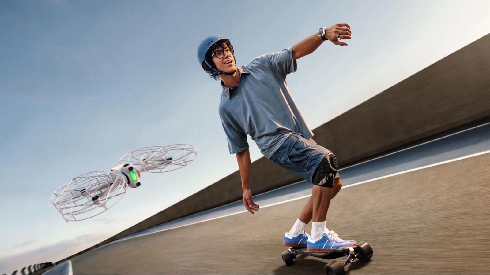A skater rides downhill while the Antigravity A1 drone with propeller guards follows him