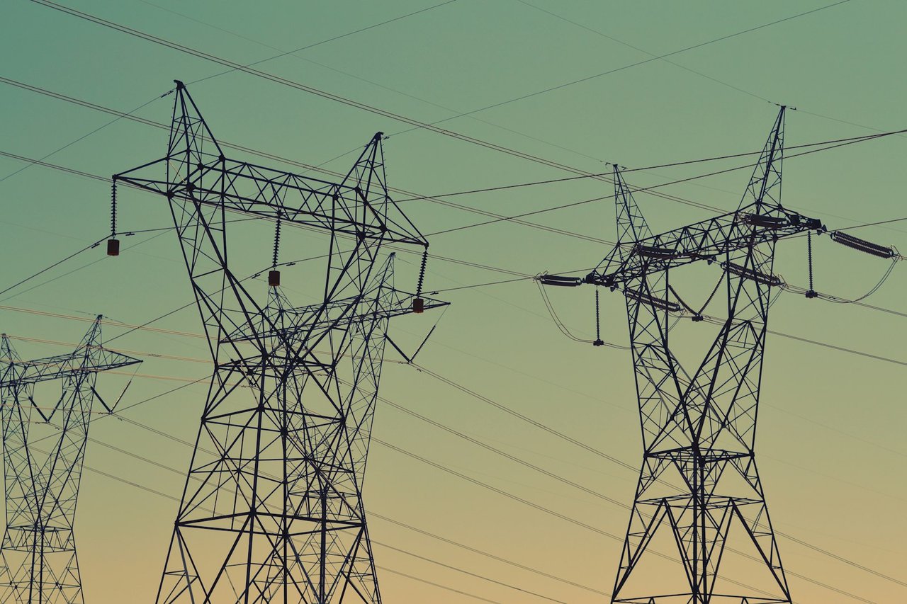 High-voltage transmission pylons carrying power to the grid at dusk