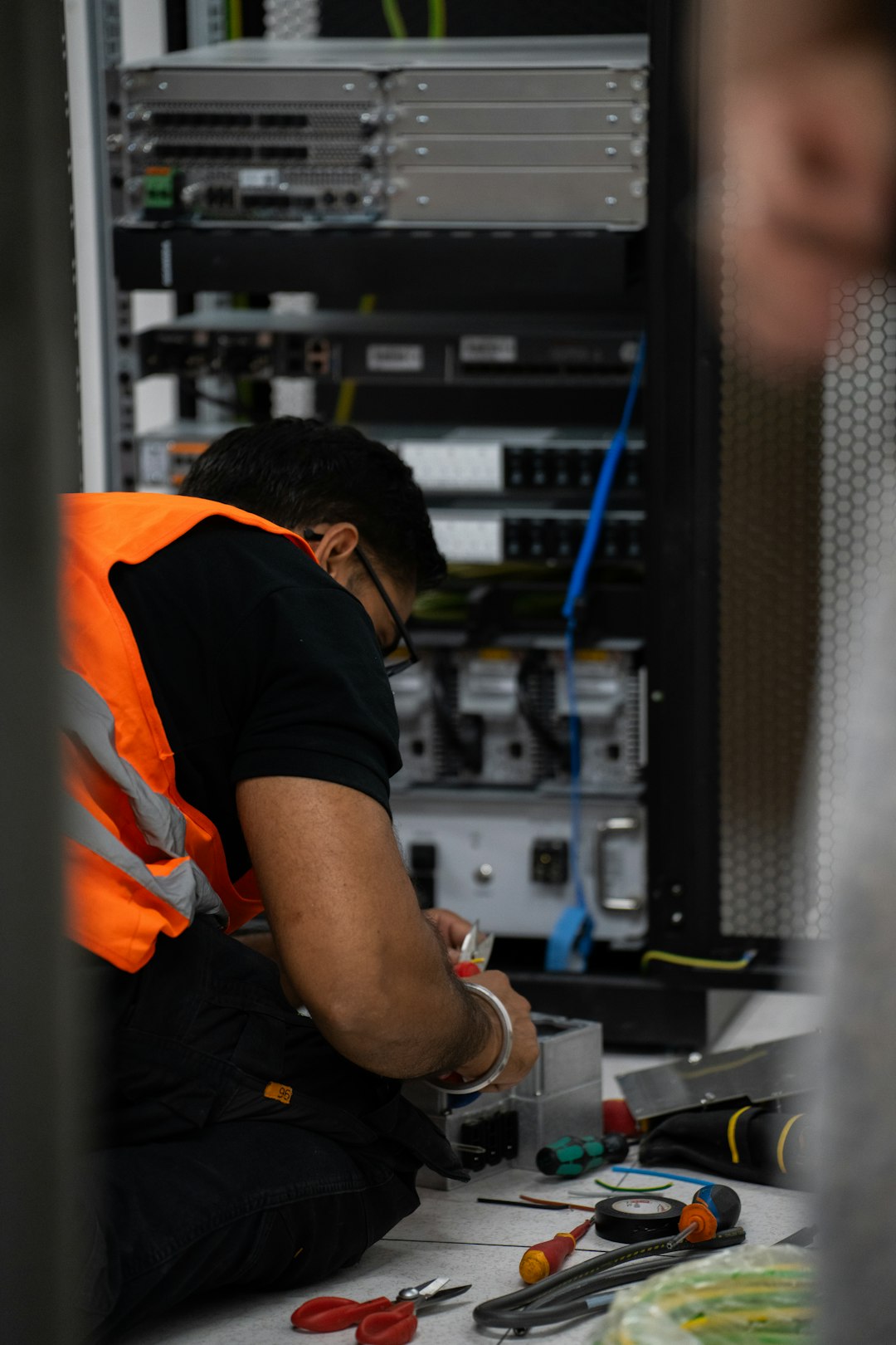 A technician working on servers in a data centre rack