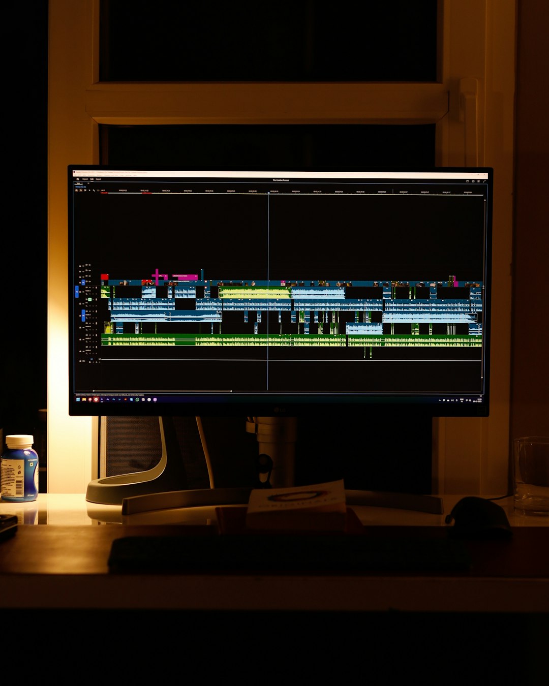 A video editing timeline open on screen in a dim editing suite
