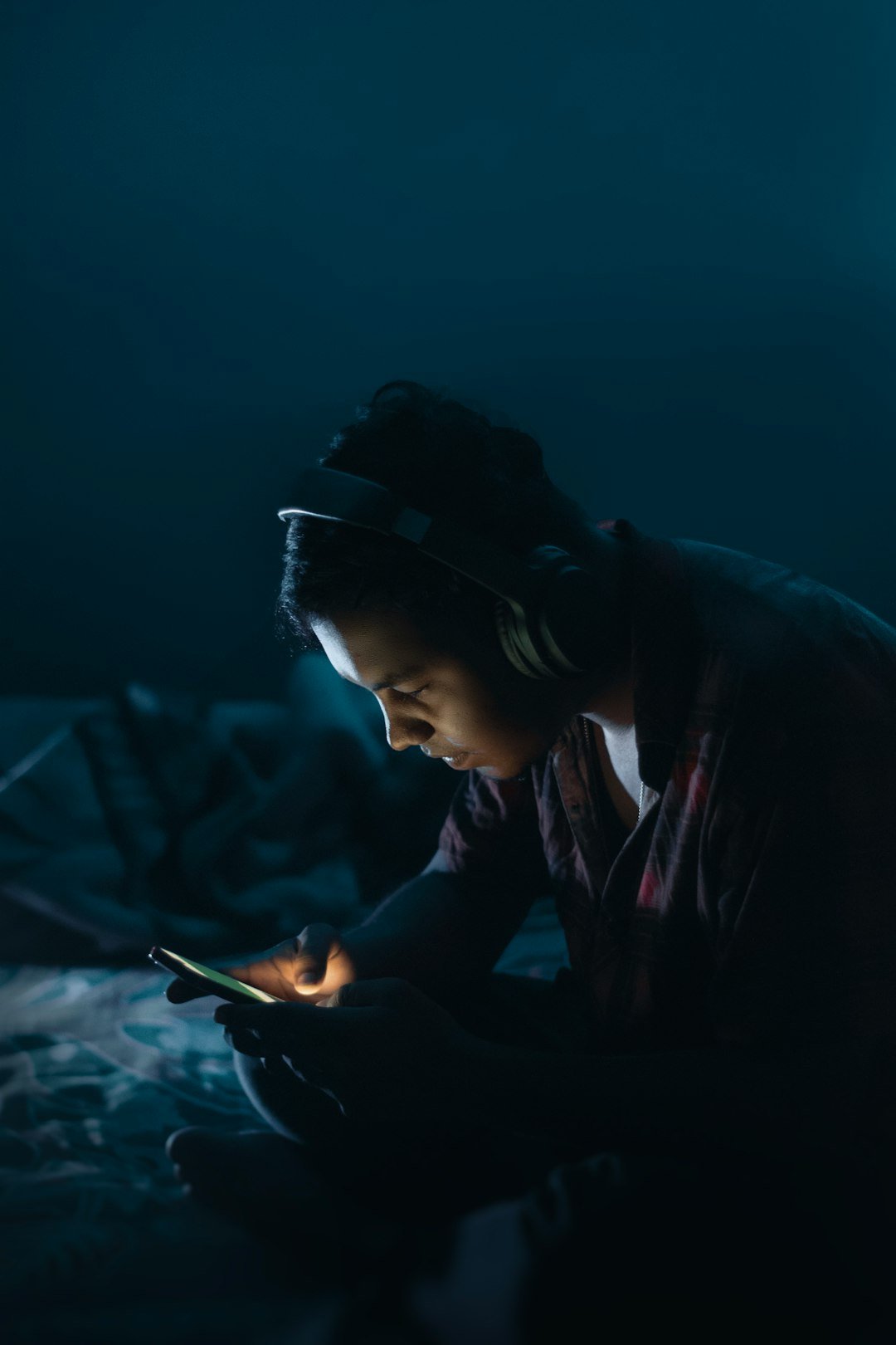 Seorang remaja melayari telefon dalam gelap pada lewat malam