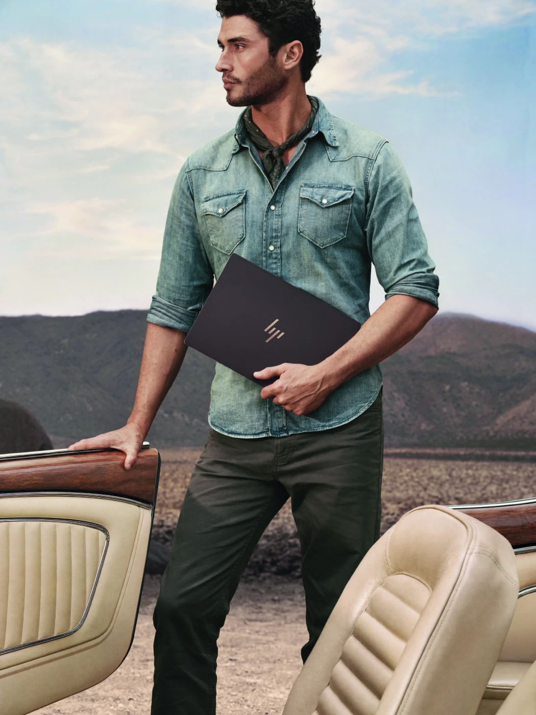 A man holds the HP OmniBook Ultra 14 Deep Espresso Limited Edition laptop showing its slim profile