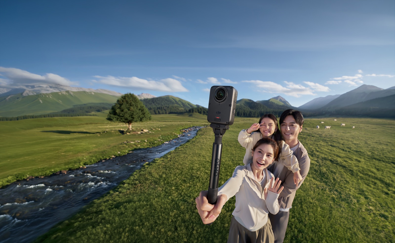 A family takes a 360-degree selfie with a DJI Osmo 360 II on a selfie stick in a green valley