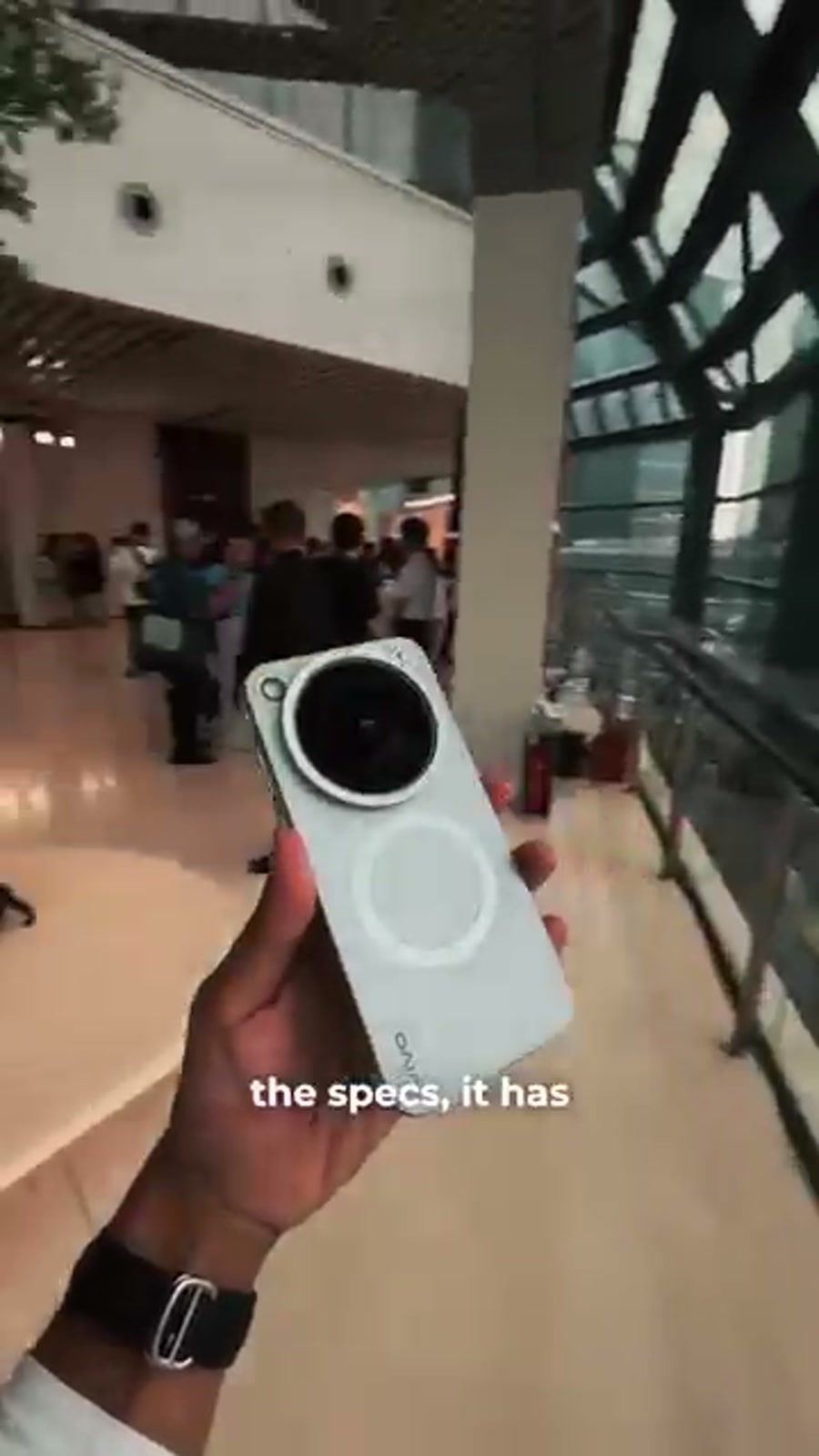 Holding the vivo X500 Pro Max with the lens attached while walking through its specs