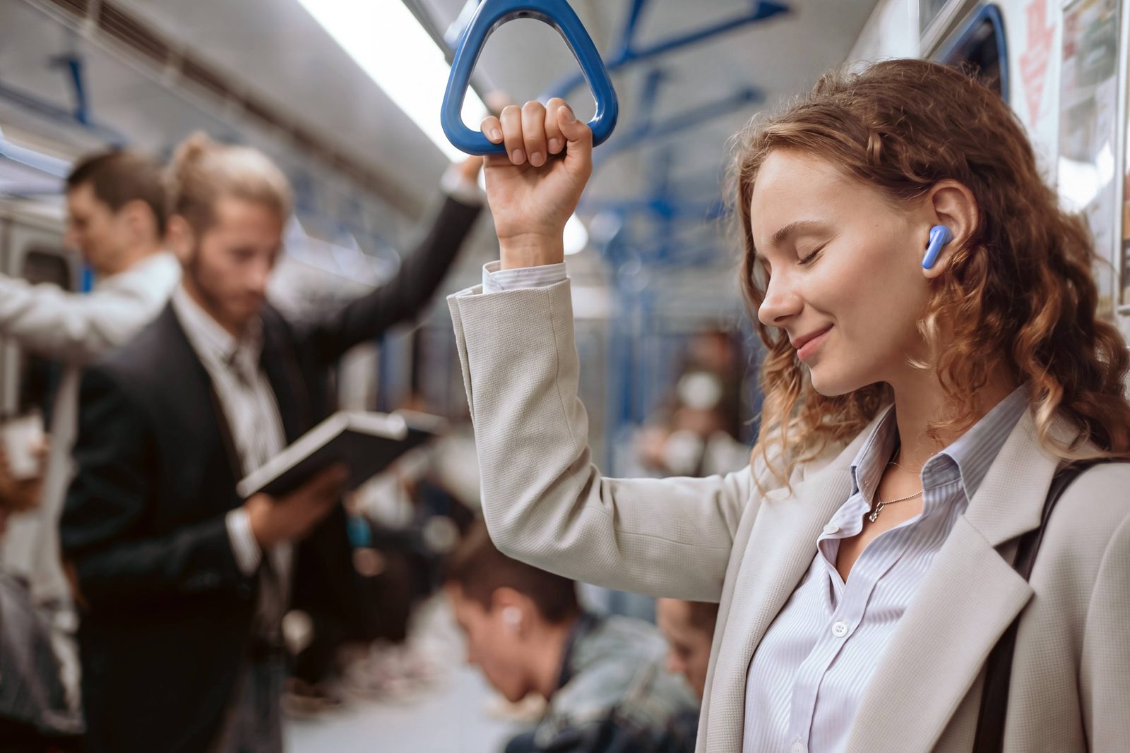 A commuter wearing the blue Huawei FreeBuds SE 5 Max earbuds on a train
