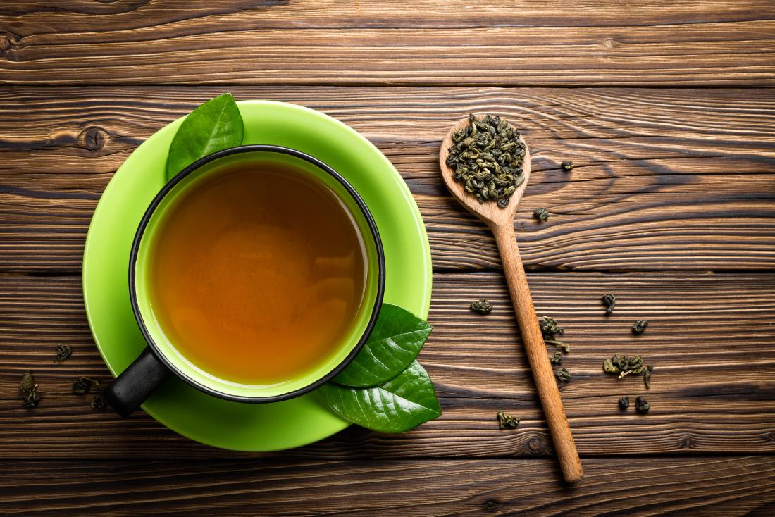 green-tea-in-cup-with-tea-leaves-on-wooden-spoon.jpg